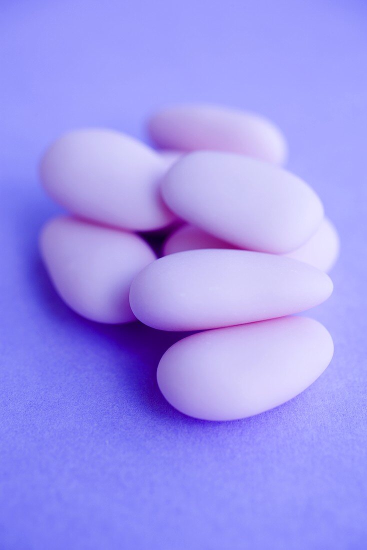 Mandeln mit rosa Zuckerglasur auf violettem Untergrund