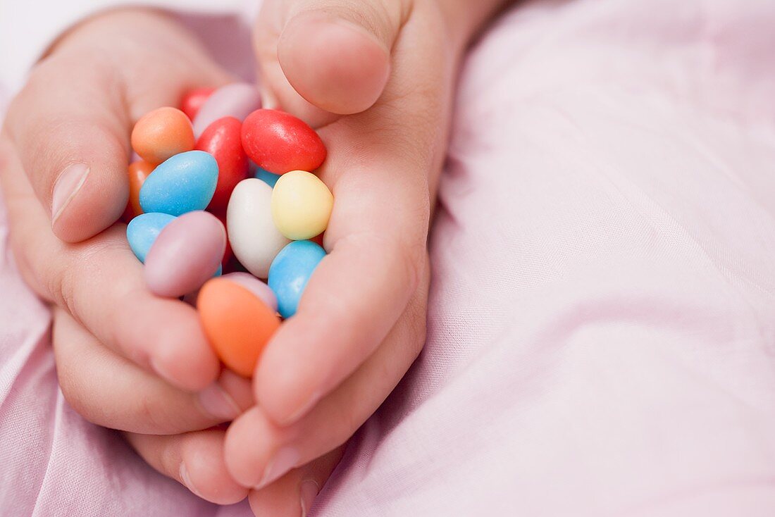 Child's hands holding coloured sugar eggs
