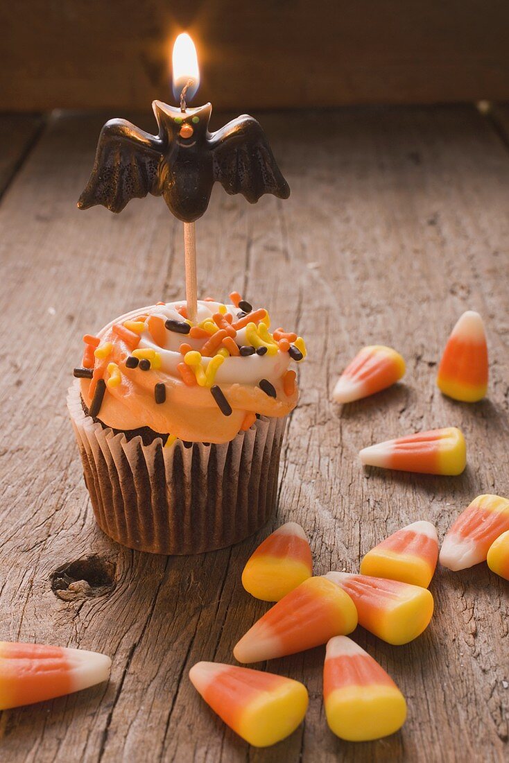 Cupcake mit Fledermauskerze und Candy Corn zu Halloween (USA)