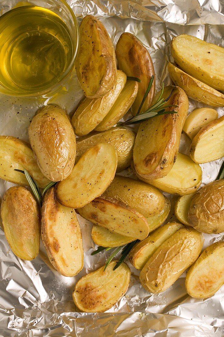 Rosemary potatoes on aluminium foil, olive oil