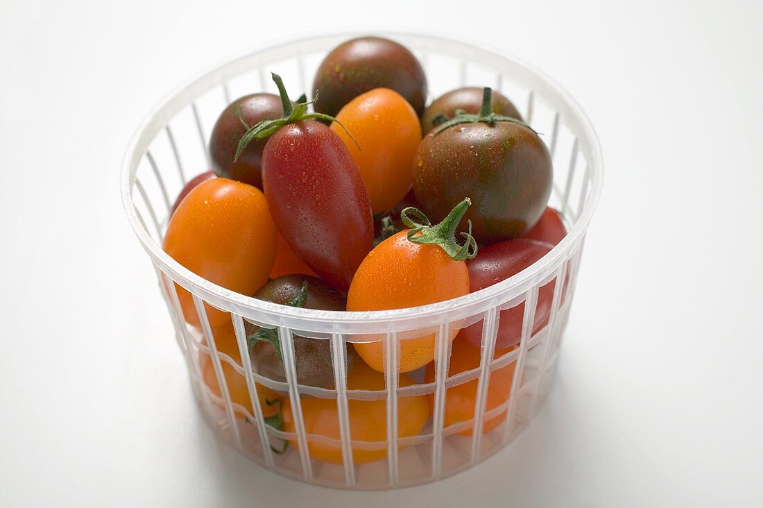Different types of tomatoes in plastic basket