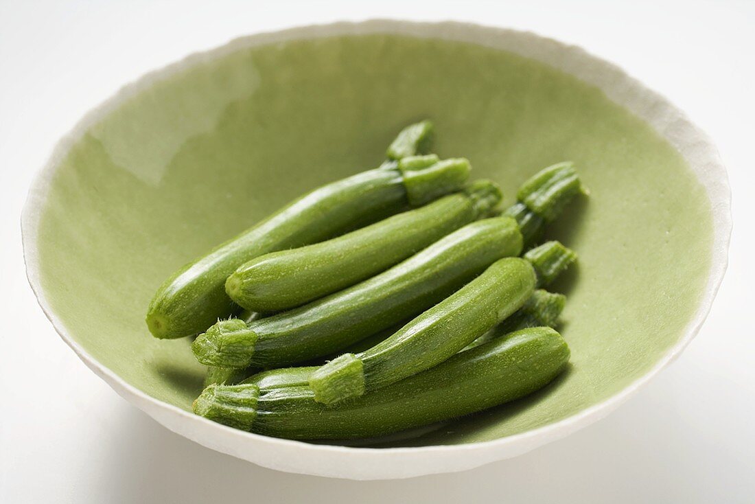 Fresh courgettes in green bowl