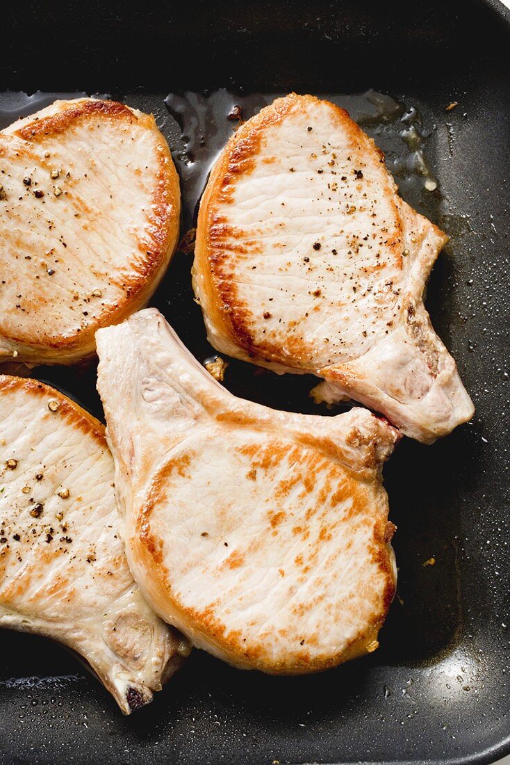 Fried pork chops in frying pan