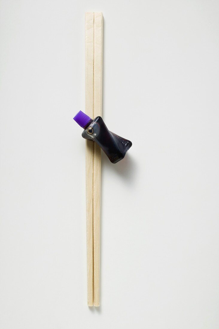 Soy sauce in small plastic bottle and chopsticks