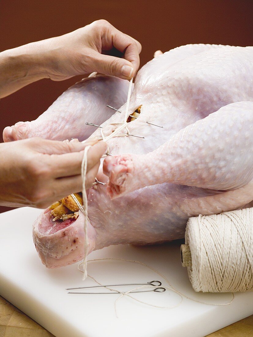 Closing up stuffed turkey with kitchen string