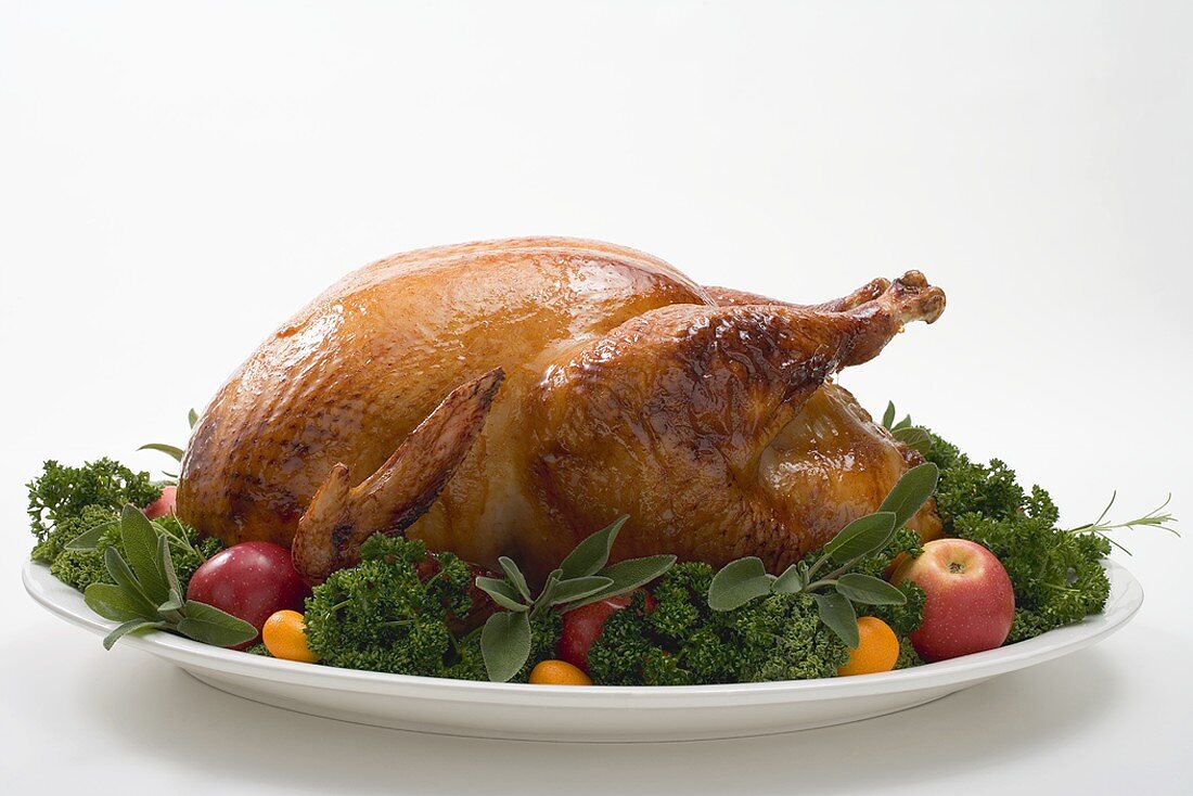 Roast turkey garnished with fruit and herbs