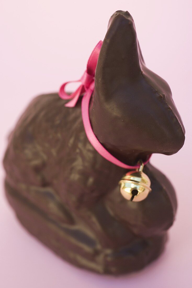 Schokoladenosterhase mit rosa Schleife und Glöckchen