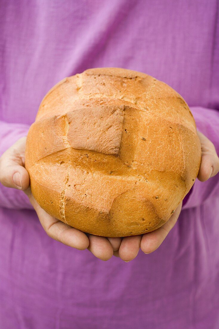 Hands holding round Easter bread