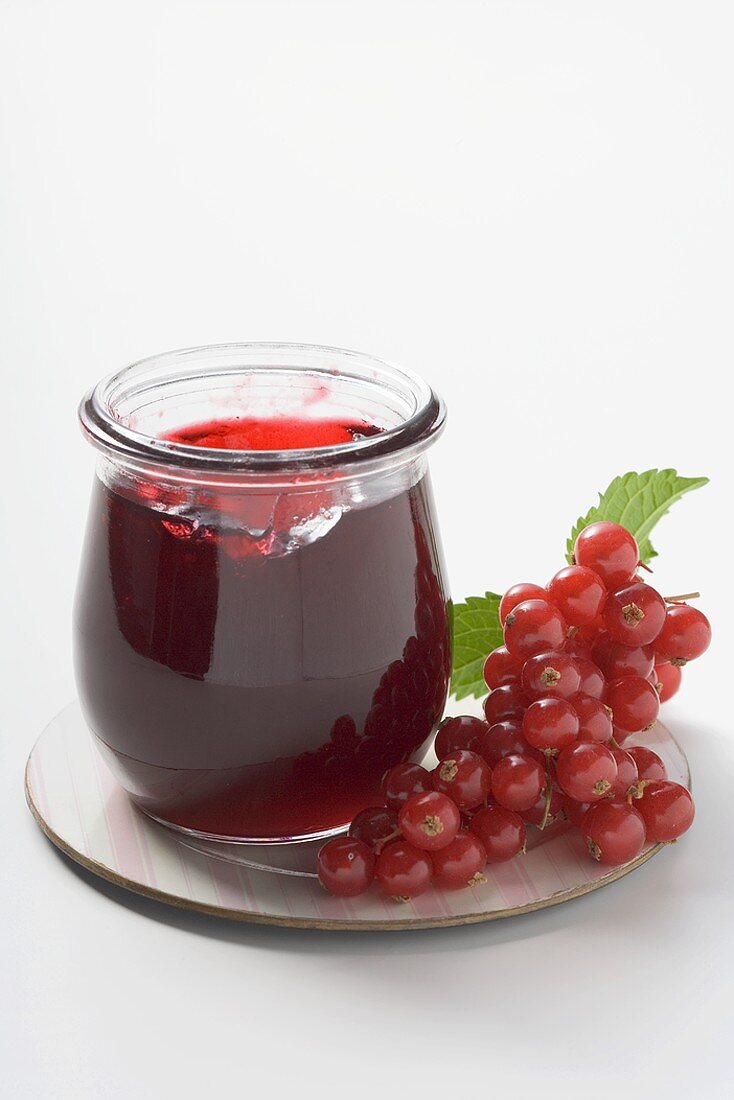 Jar of redcurrant jelly, redcurrants beside it