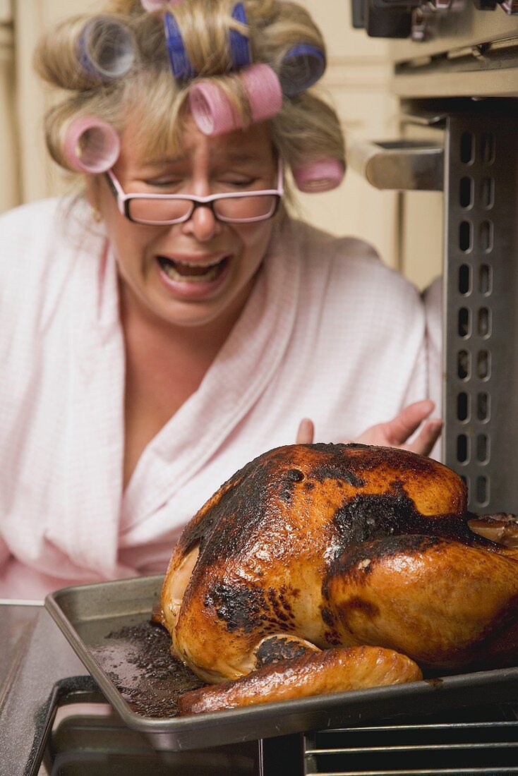 Despairing housewife with burnt turkey