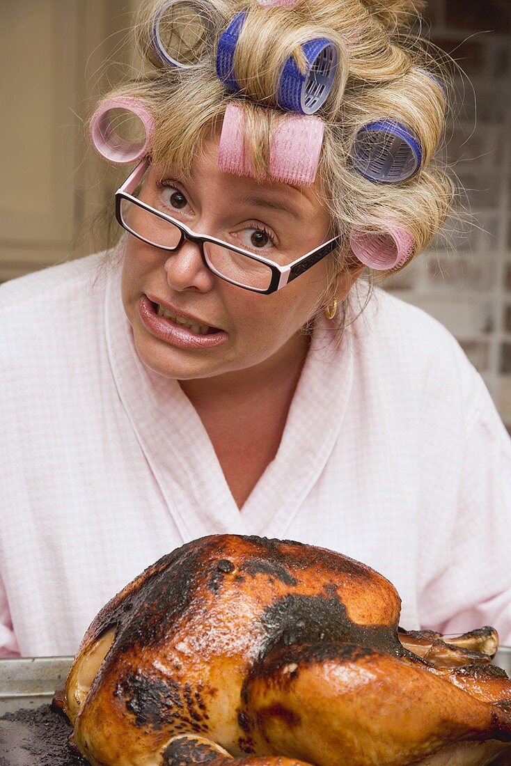 Entsetzte Hausfrau mit verbranntem Truthahn