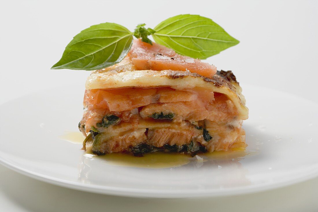 Portion of salmon lasagne with basil
