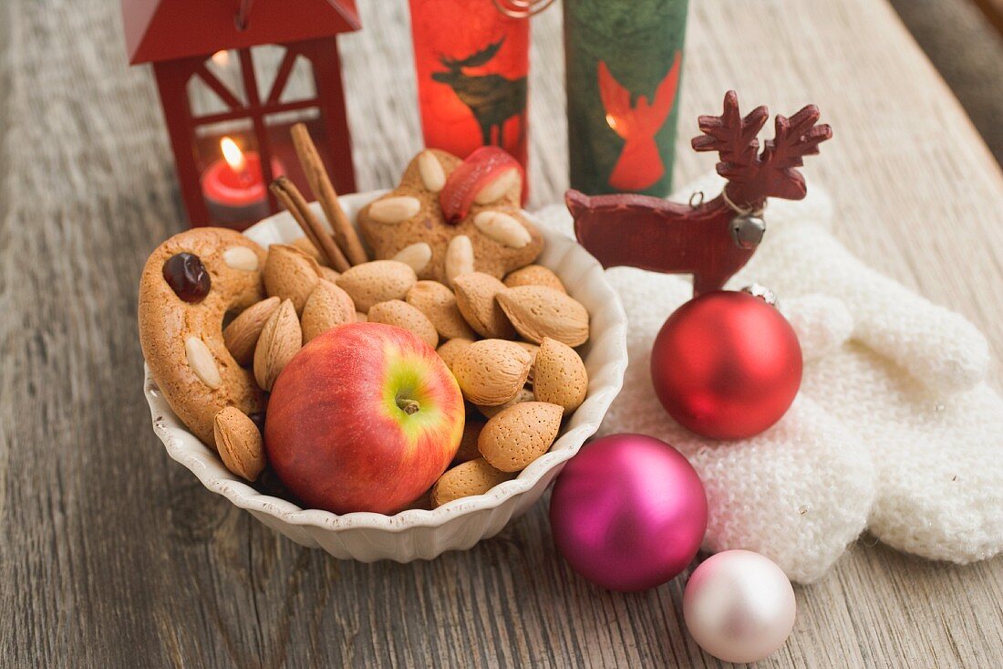 Weihnachtsdeko mit Apfel, Nüssen, Laterne, Handschuhen