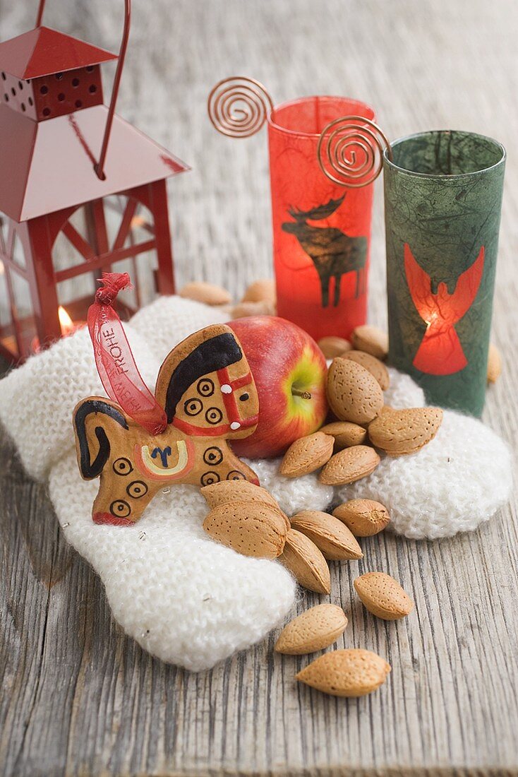 Weihnachtsdeko mit Apfel, Mandeln, Laterne, Handschuhen