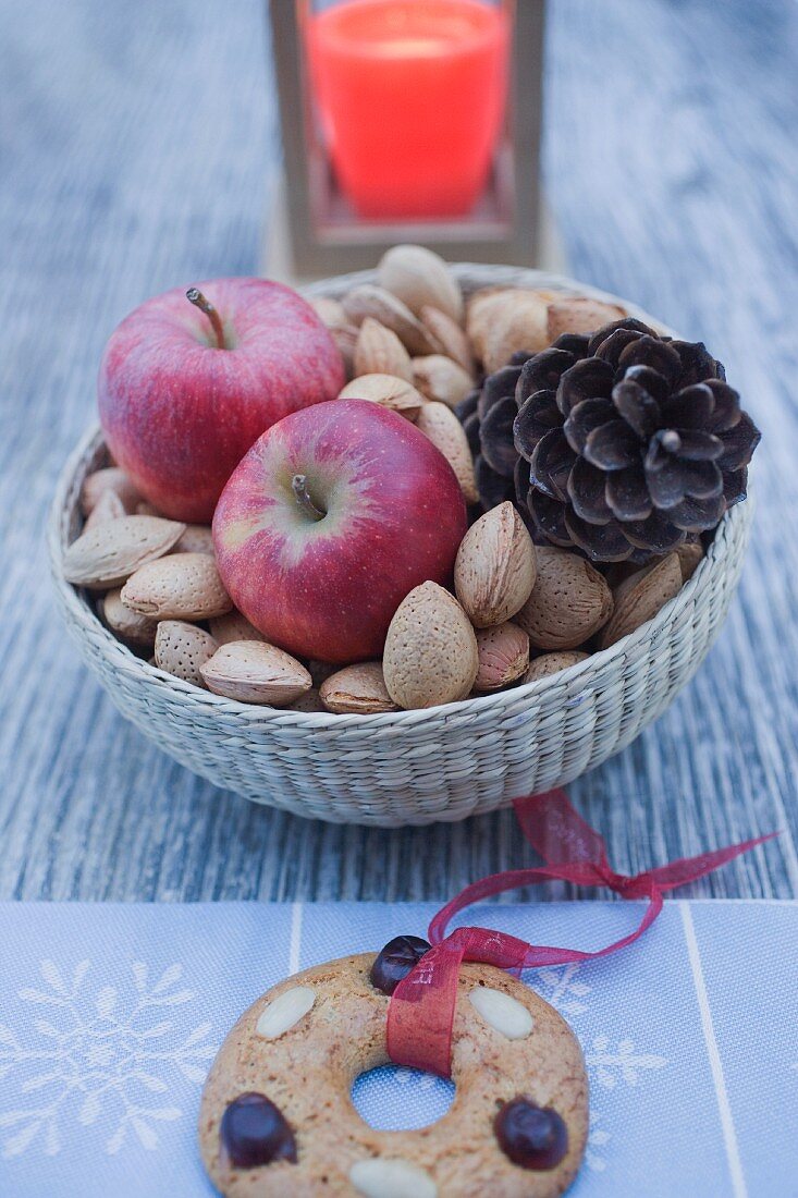 Christmas decoration with apples, nuts, candle & gingerbread