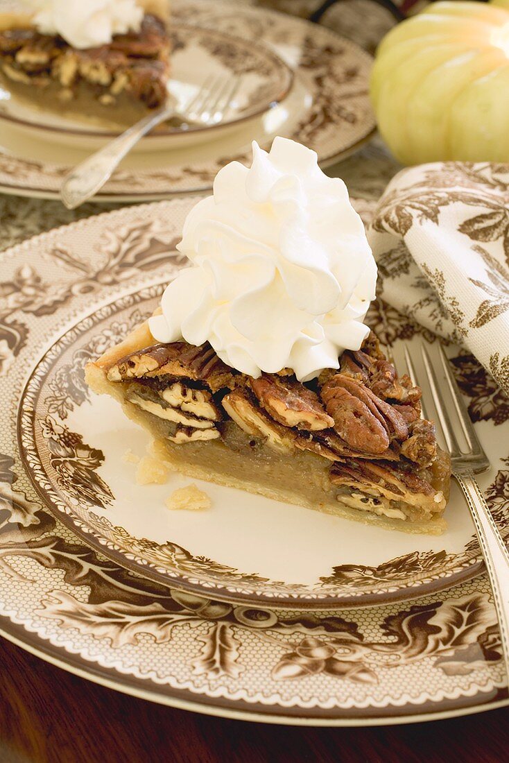 Piece of pecan pie with cream for Thanksgiving