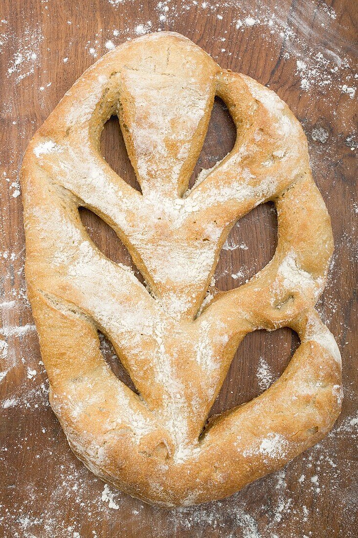 Ciabatta on wooden background with flour (overhead view)