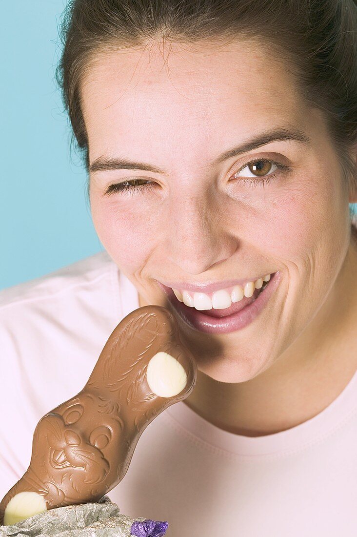 Woman biting into chocolate Easter Bunny