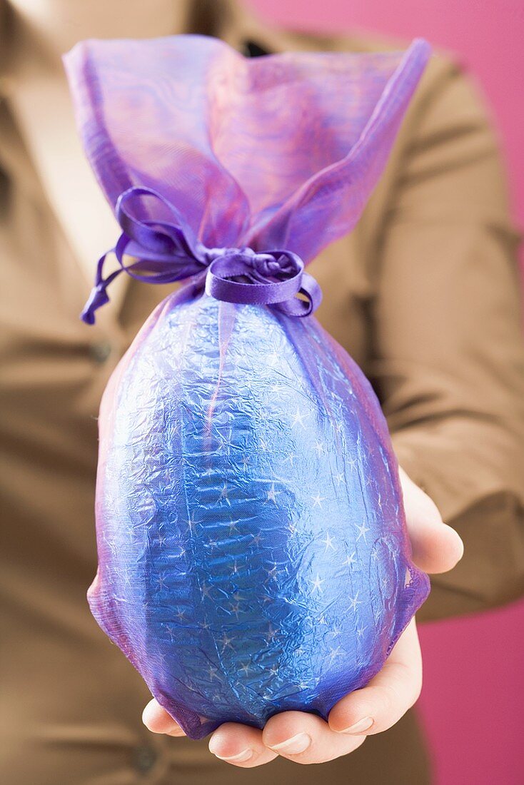 Woman holding large chocolate Easter egg