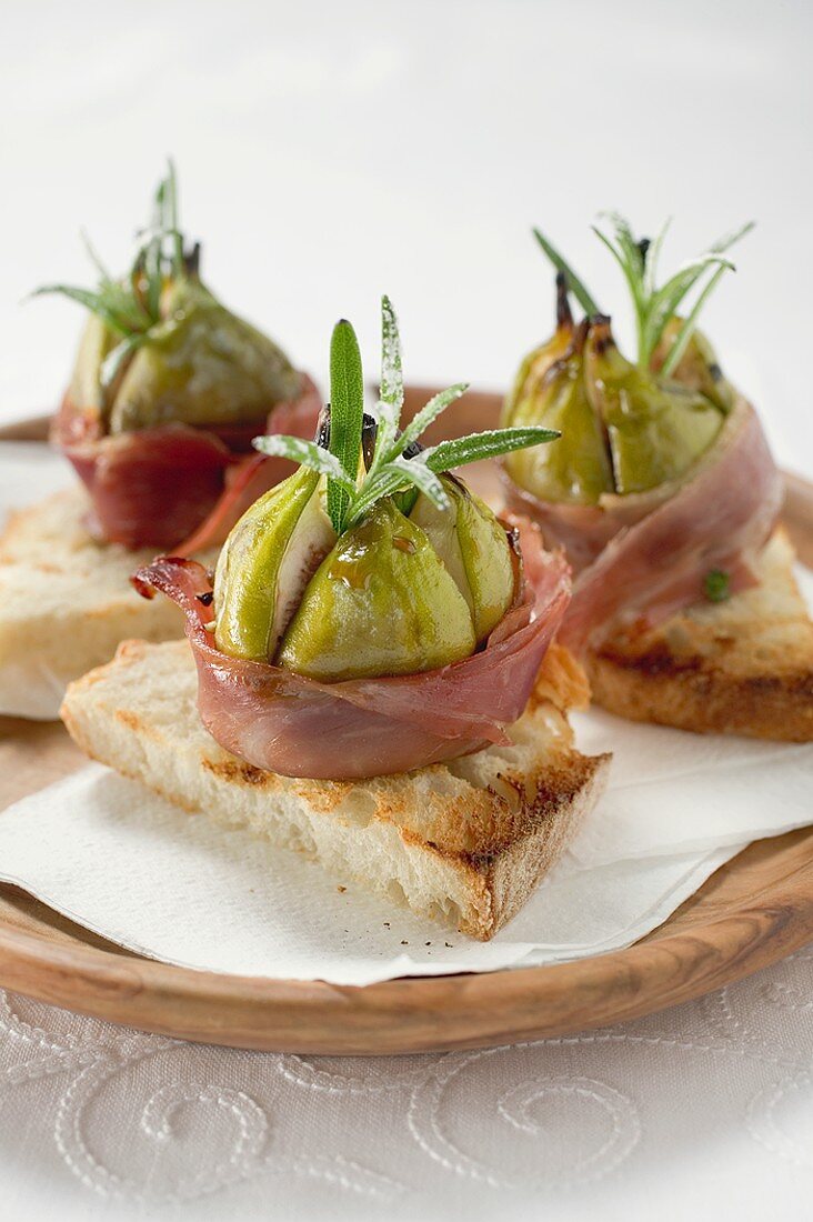 Figs wrapped in raw ham on toast