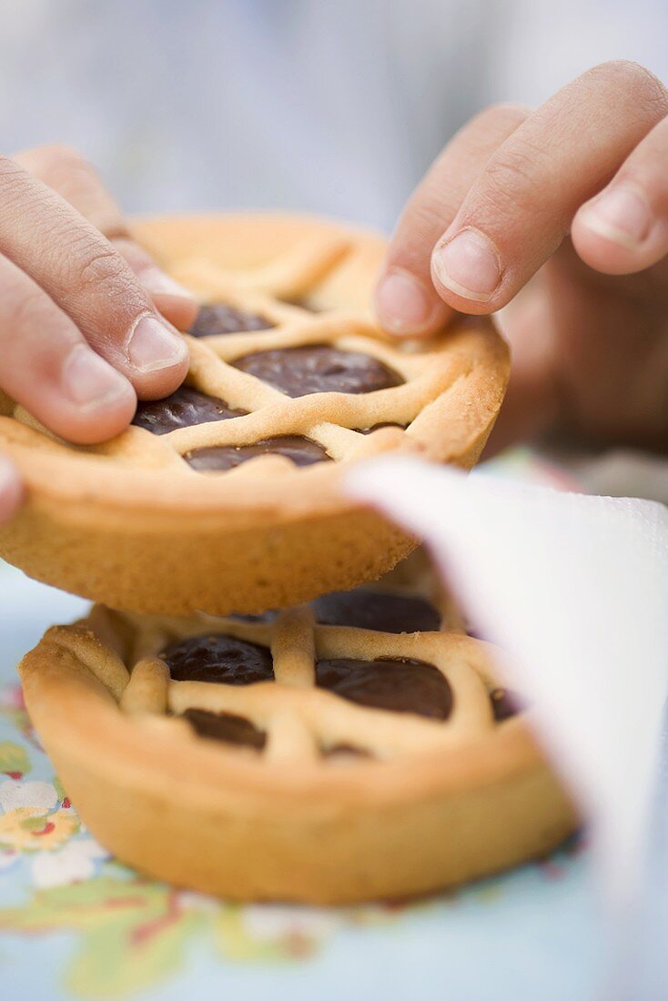 Child's hands holding chocolate tartlet