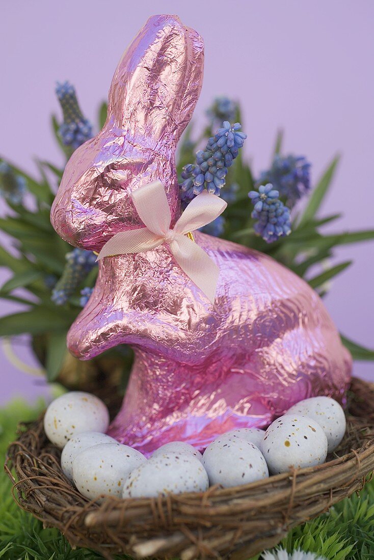 Pink Easter Bunny & Easter eggs in basket, spring flowers
