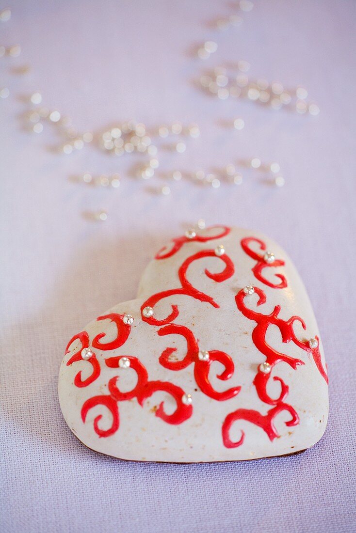 Herzförmiger Lebkuchen mit weisser Glasur und Zuckerperlen