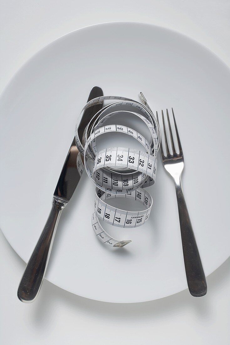 Knife and fork and tape measure on plate