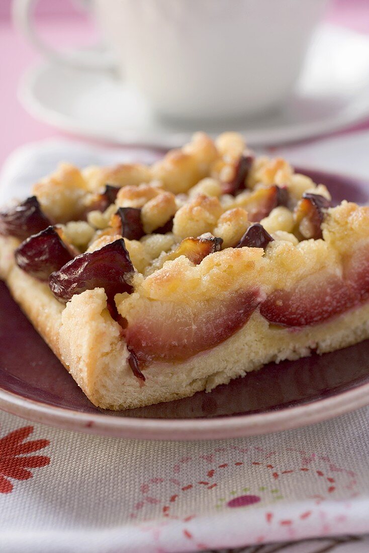 Piece of plum cake in front of coffee cup