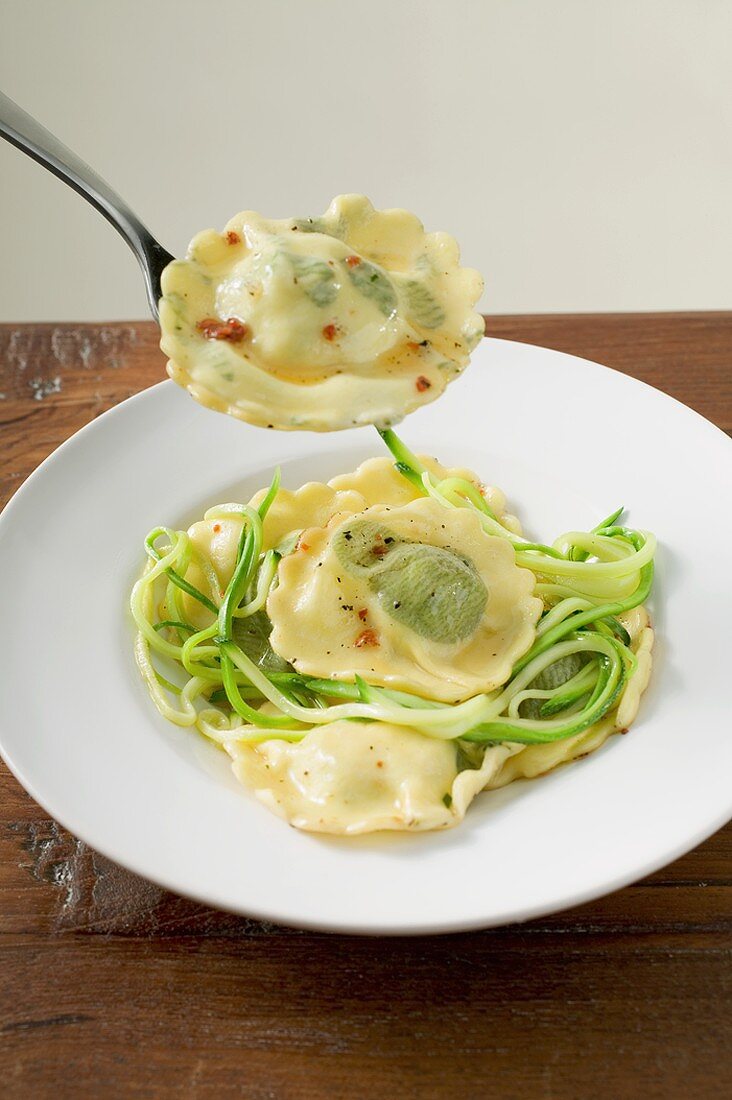 Ravioli mit Zucchinistreifen auf Teller und Gabel