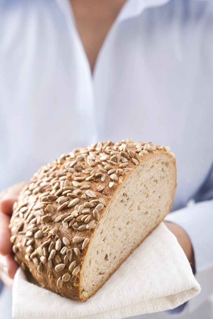 Frau hält angeschnittenes Sonnenblumenbrot