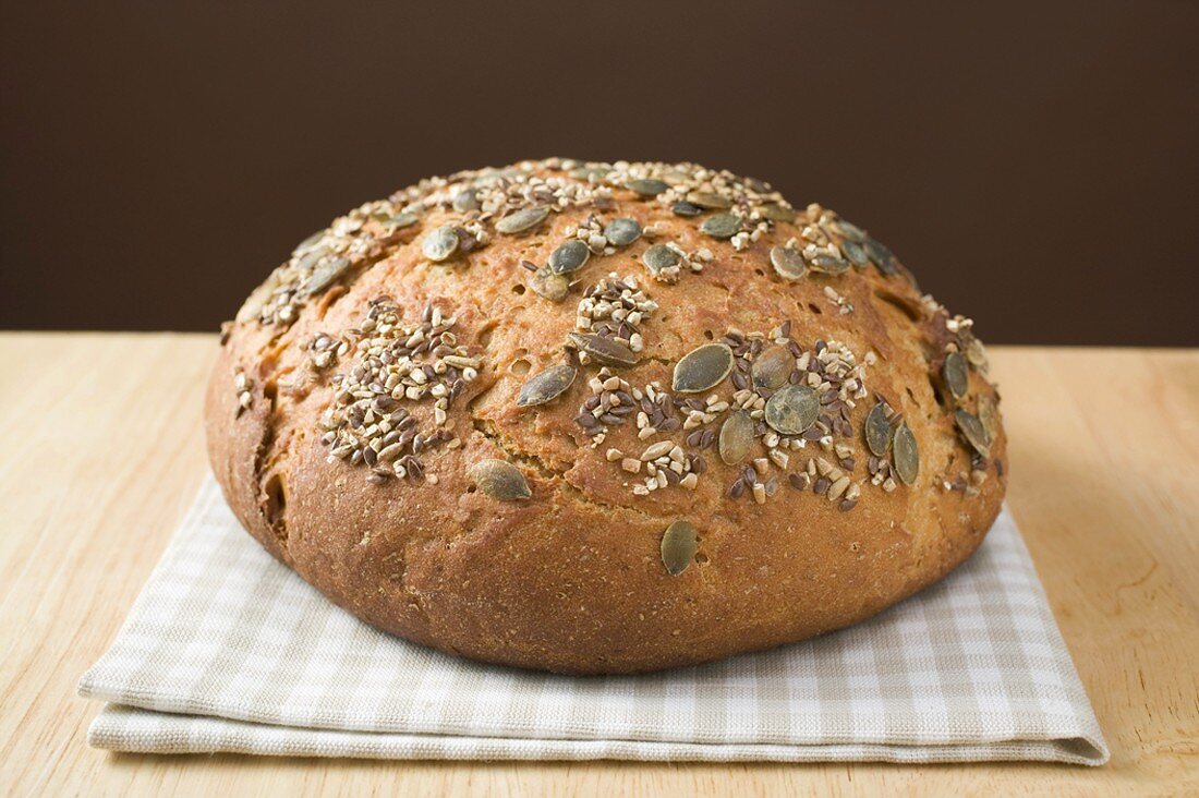 Wholemeal bread with pumpkin seeds on tea towel
