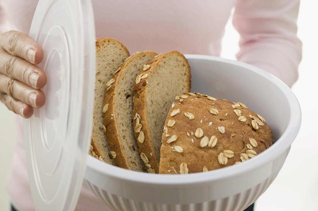 Woman holding oat bread in food storage container