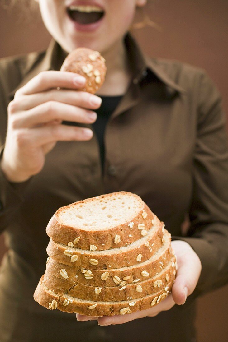 Frau hält Brotscheiben (Haferflockenbrot)