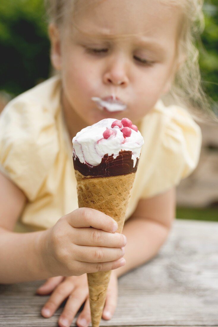 Kleines Mädchen isst Eistüte