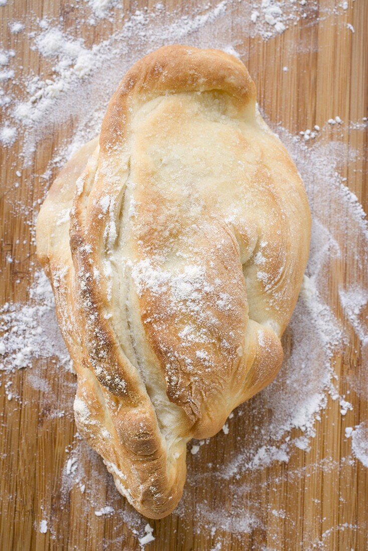 Rustikales Brot mit Mehl auf Holzuntergrund