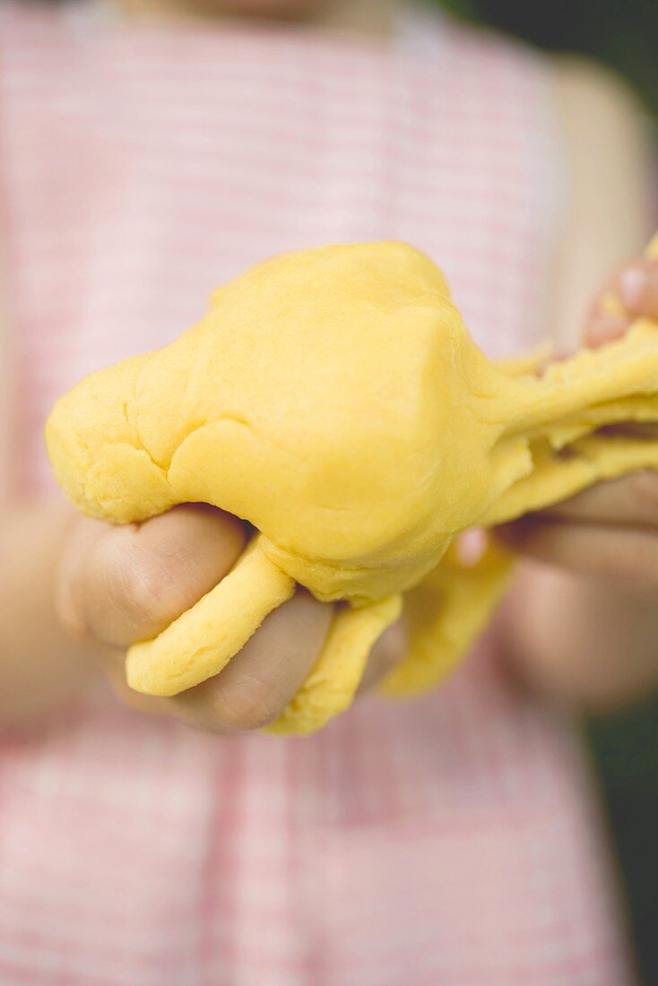 Child's hands kneading dough