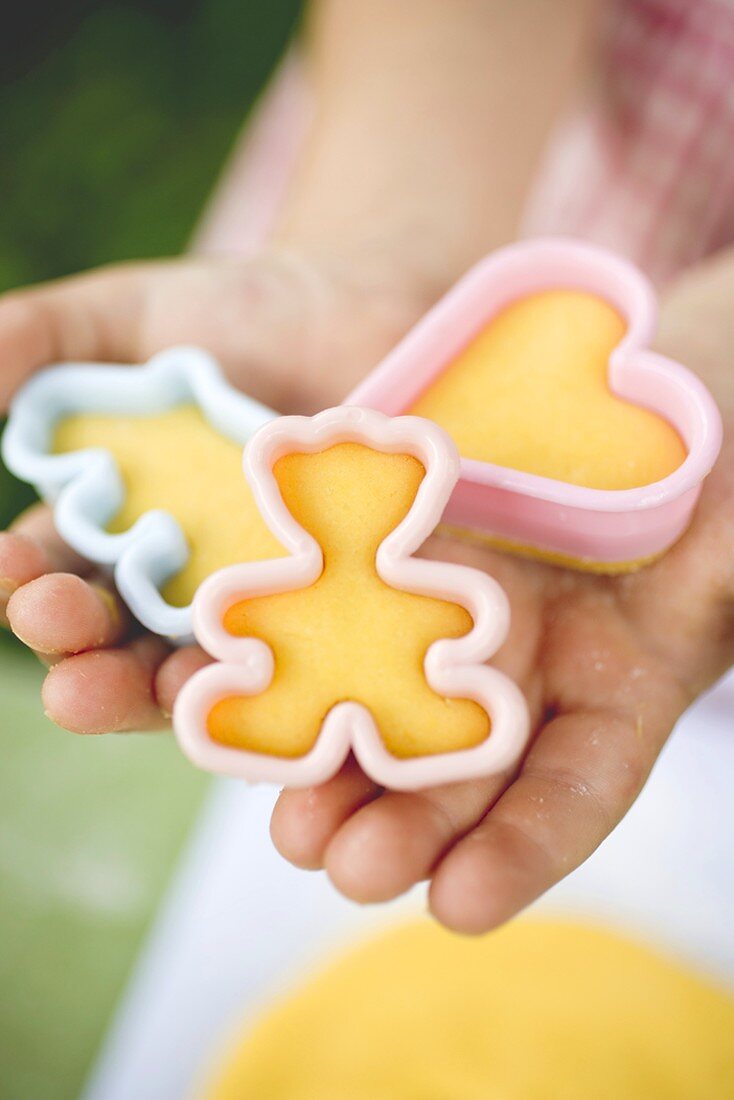 Child holding cut-out biscuits