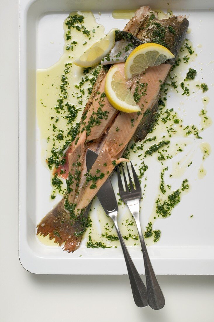 Salmon trout with herb butter and lemon wedges