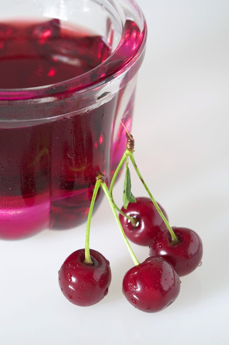 Cherry jelly in small jelly mould, fresh cherries beside it