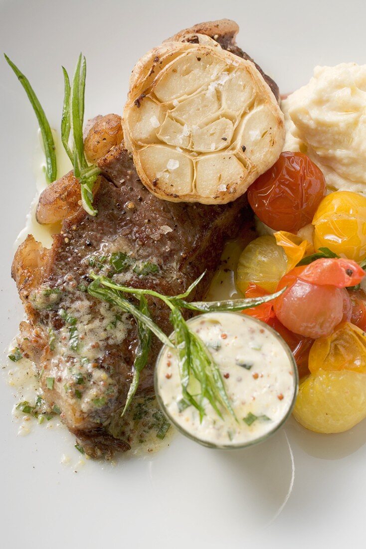 Beef steak with garlic, cherry tomatoes and mustard butter