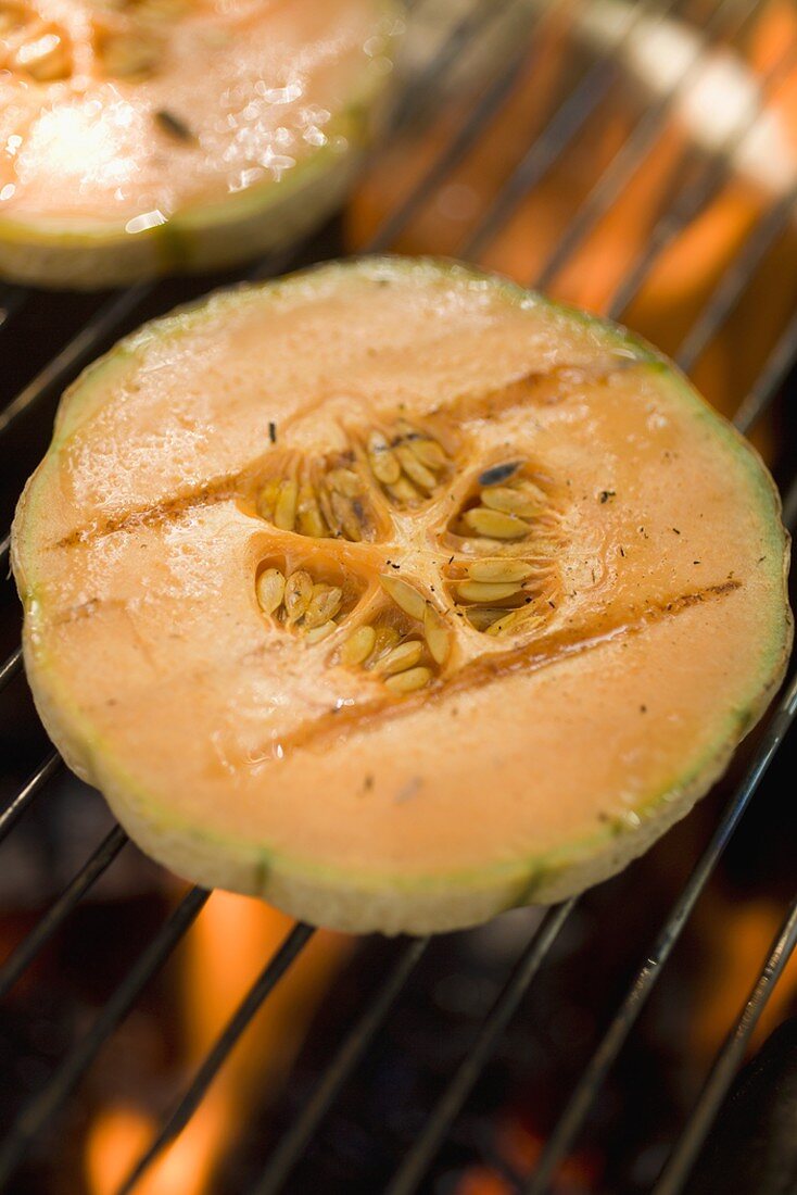 Melon slices on barbecue grill rack