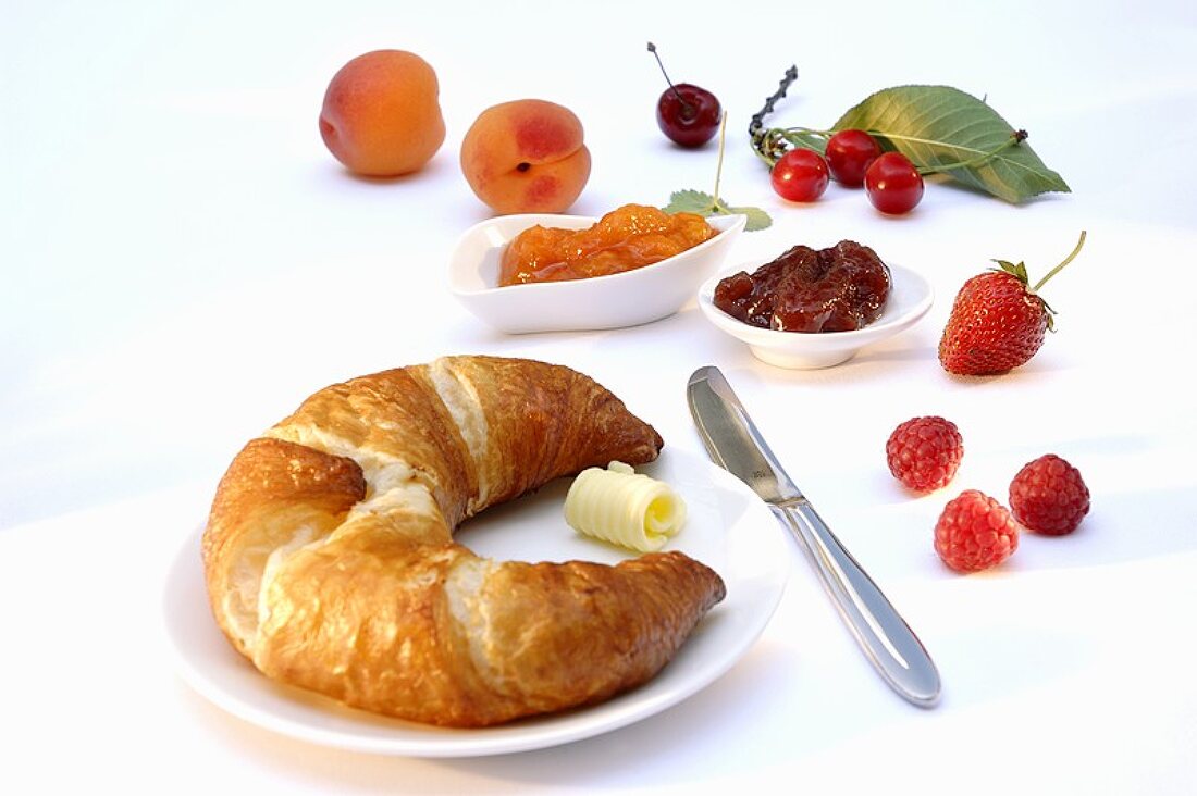 Croissant, jam and fresh fruit for breakfast