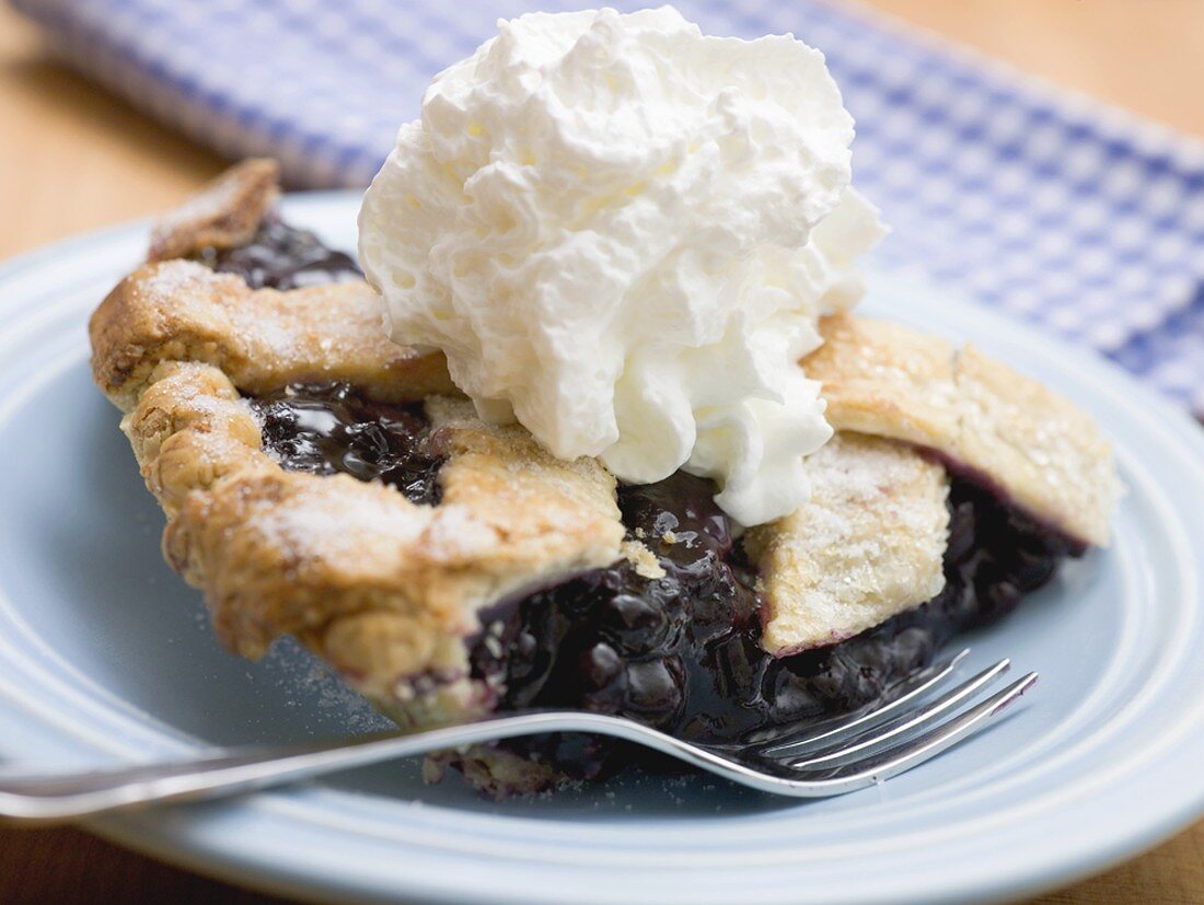 Piece of blueberry pie with cream