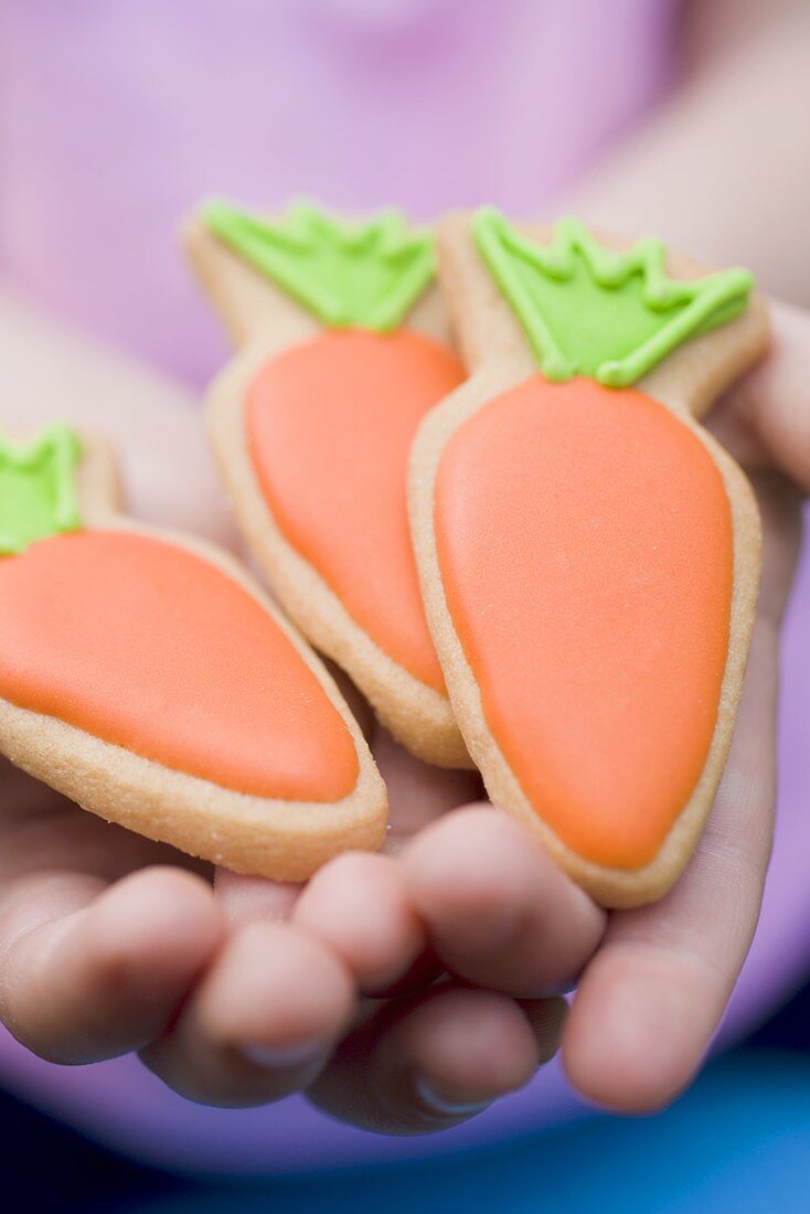 Kinderhände halten Osterplätzchen