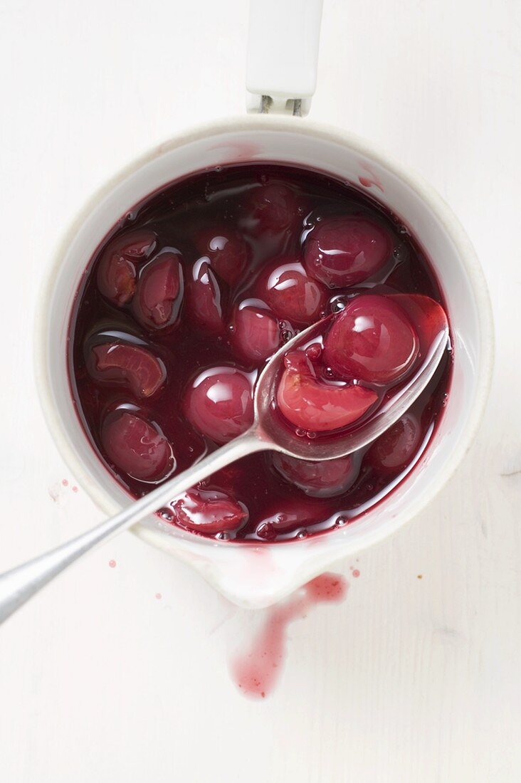 Cherry compote in pan with spoon