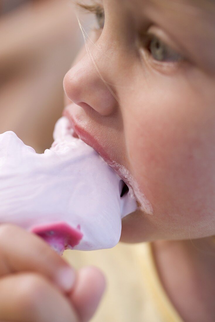 Kleines Mädchen isst Eis am Stiel (Close Up)