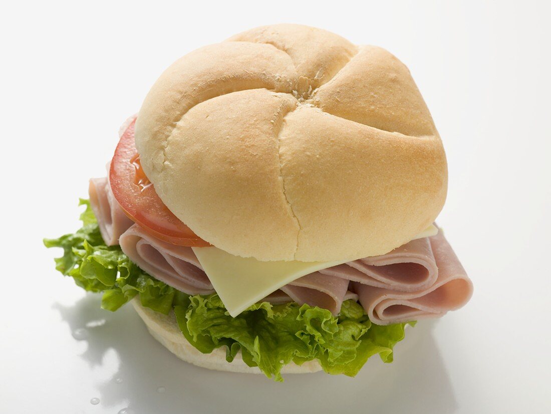 Bread roll filled with ham, cheese, lettuce and tomato