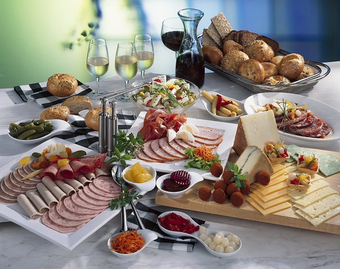 Kaltes Buffet mit Wurstplatten, Käse, Salat, Brot und Wein