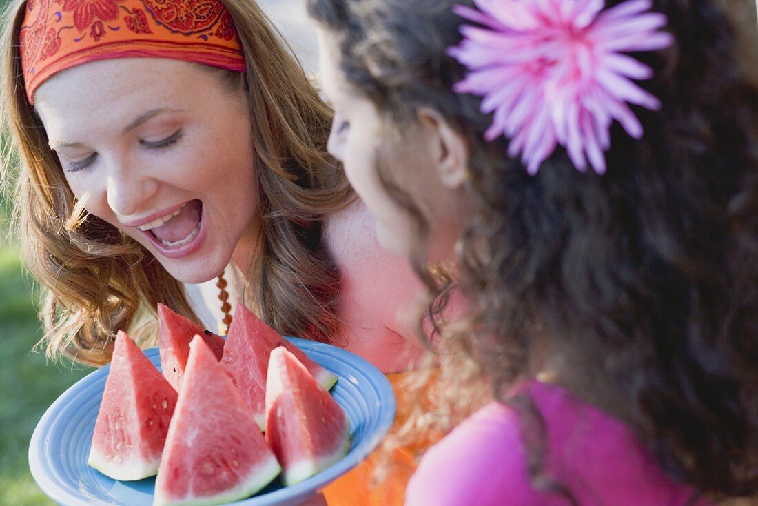 Zwei junge Frauen mit Wassermelonenschnitzen